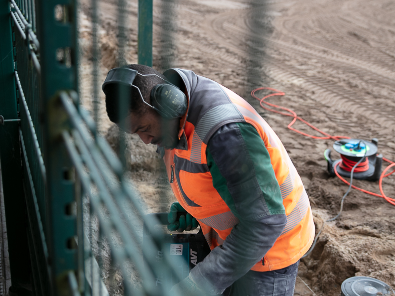 Ein Mitarbeiter von heiler arbeitet auf einer Baustelle im Sportplatzbau
